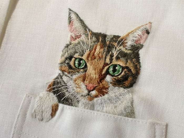A stunning hand embroidery of a cat on a shirt.